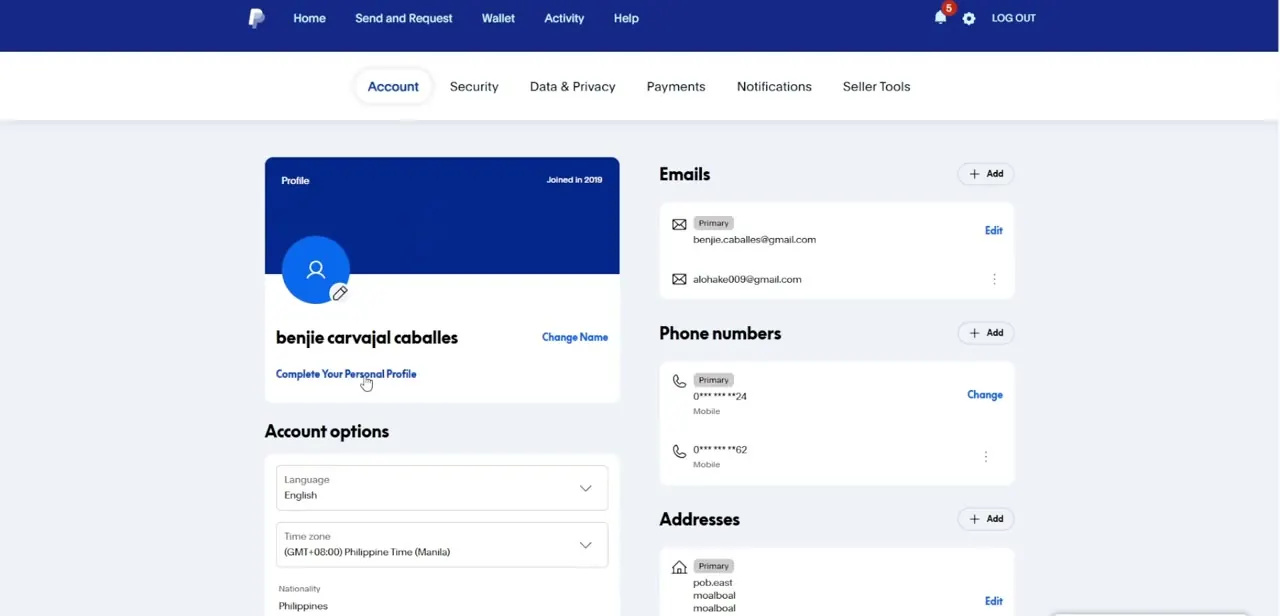 The Account settings page, showing the profile name field with a Change Name link, plus the emails, phone numbers, and addresses tied to the account.